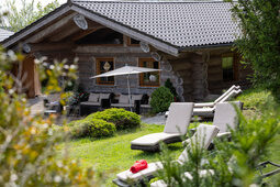 Spa-Ansicht auf die Blockhütte, davor Gartenwiese mit Liegen zum entspannen vom Hotel Konradshof in Besenfeld
