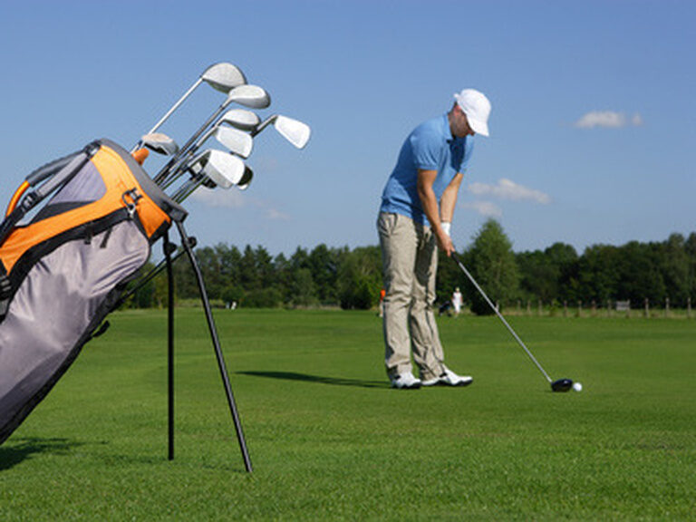 Mann beim Abschlag auf einem Golfplatz