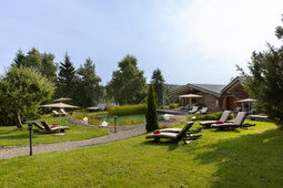 Gartenwiese vor den Blockhütten, lädt zum relaxen und baden im Nautrschwimmteich vom Hotel Konradshof in Besenfeld ein